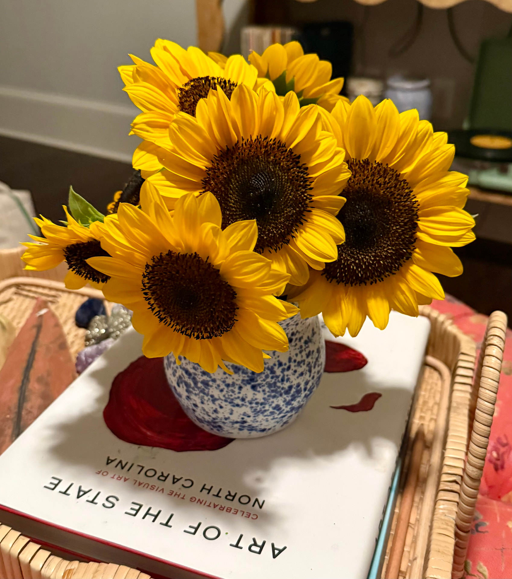 Round speckled vase holding sunflowers